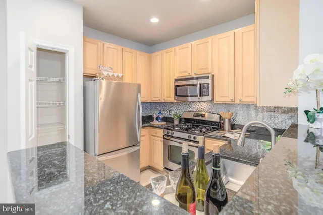a kitchen with stainless steel appliances granite countertop a refrigerator stove and sink