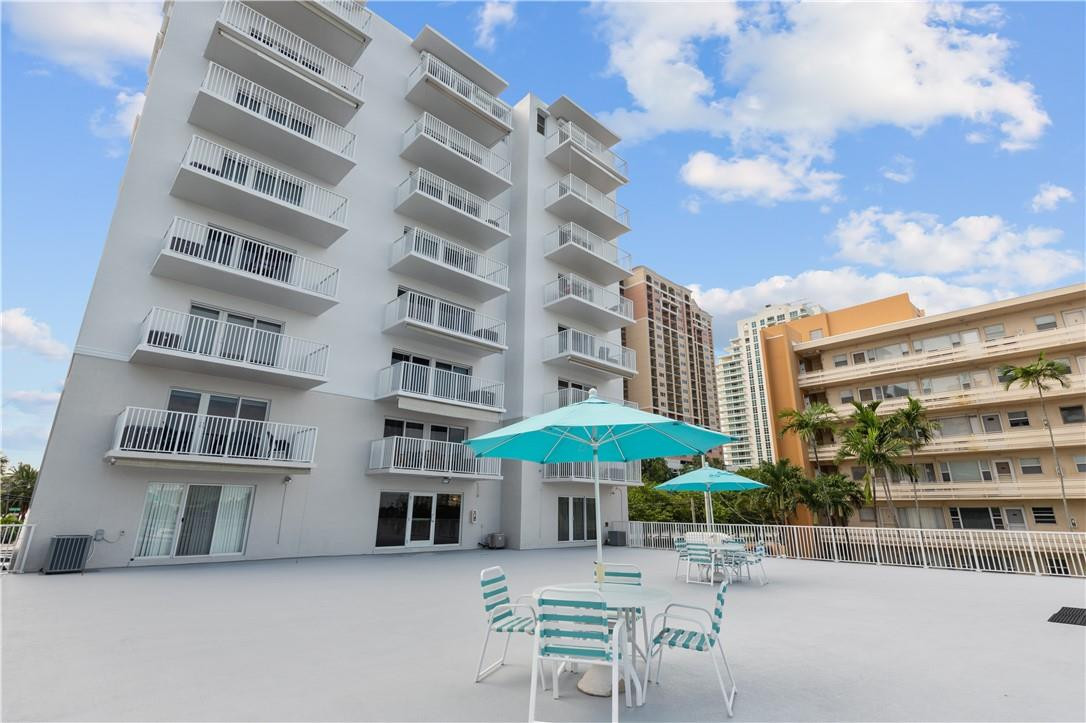 95 North Birch Road, Unit 405 Fort Lauderdale, FL 33304 - Photo 30 of 34 a patio with a table and chairs under an umbrella