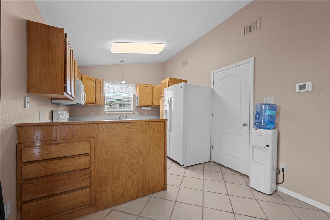 501 Jane Street Corpus Christi, TX 78418 - Photo 9 of 39 a kitchen with a refrigerator and cabinets