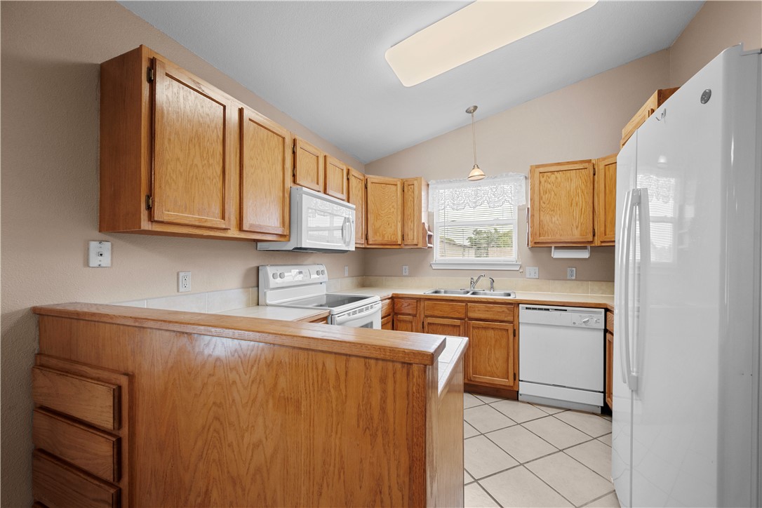 501 Jane Street Corpus Christi, TX 78418 - Photo 10 of 39 a kitchen with stainless steel appliances granite countertop a refrigerator sink and cabinets