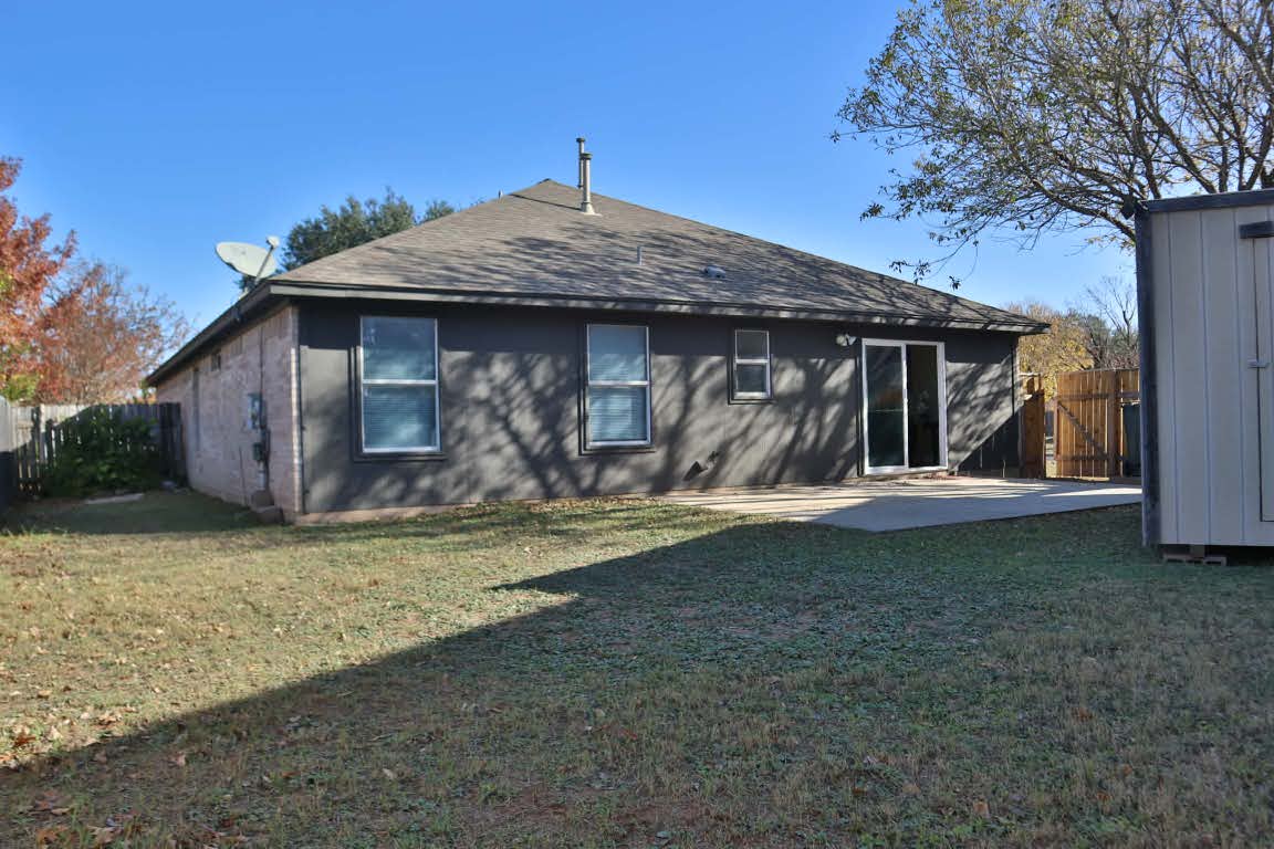 717 Blair Avenue Bastrop, TX 78602 - Photo 27 of 27 Back of house with a patio area and roof with shingles
