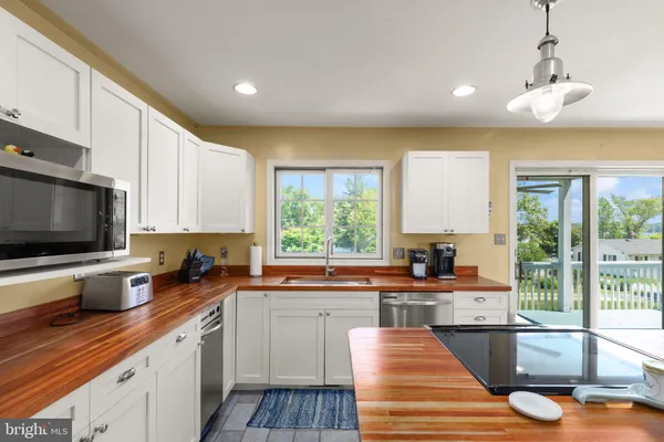 a kitchen with stainless steel appliances kitchen island granite countertop a sink and cabinets
