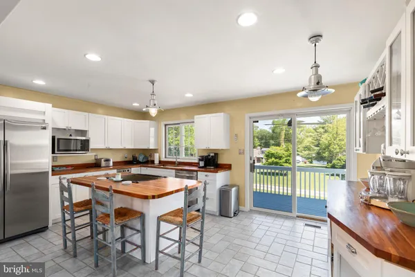 a kitchen with stainless steel appliances granite countertop a stove a refrigerator a oven a sink with a dining table and chairs