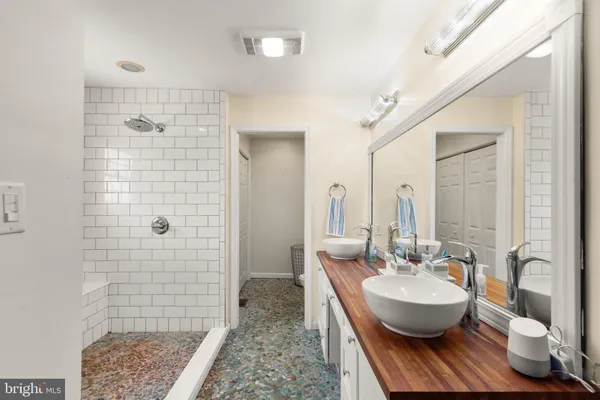 a spacious bathroom with 2 sink and a mirror