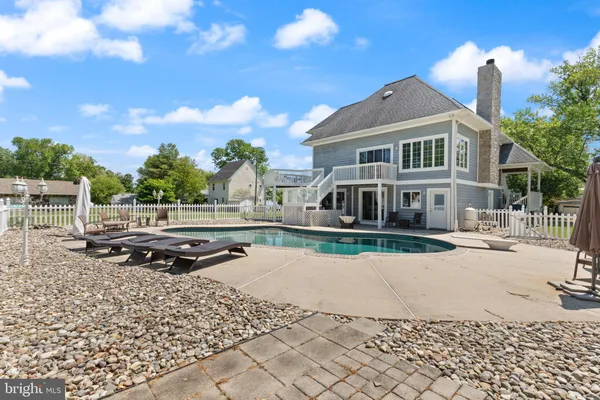 an aerial view of a house with swimming pool and large trees