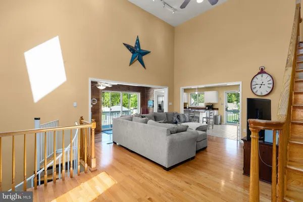 a living room with furniture a rug potted plant and a window