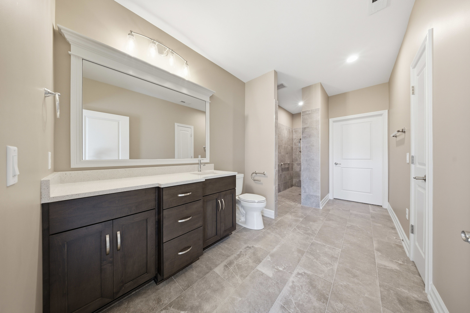 437 Stearn Drive, Unit 437 Genoa, IL 60135 - Photo 29 of 50 a bathroom with a double vanity sink a toilet and a mirror