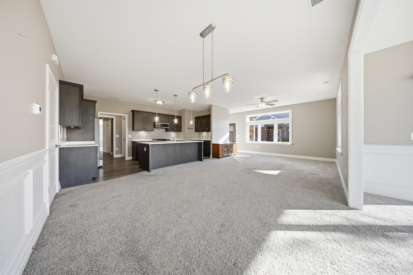 437 Stearn Drive, Unit 437 Genoa, IL 60135 - Photo 32 of 50 a open kitchen with kitchen island a stove a refrigerator a sink dishwasher with a dining table and chairs