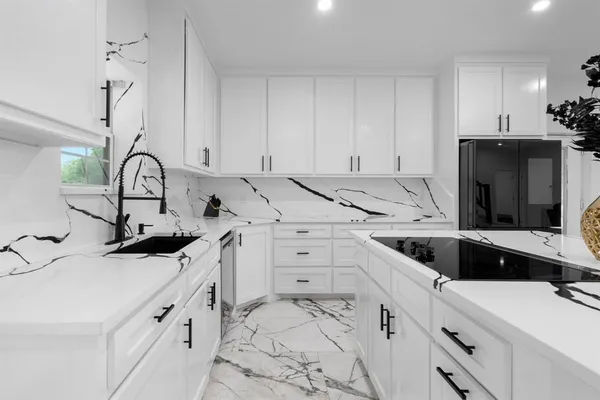 a kitchen with white cabinets and appliances