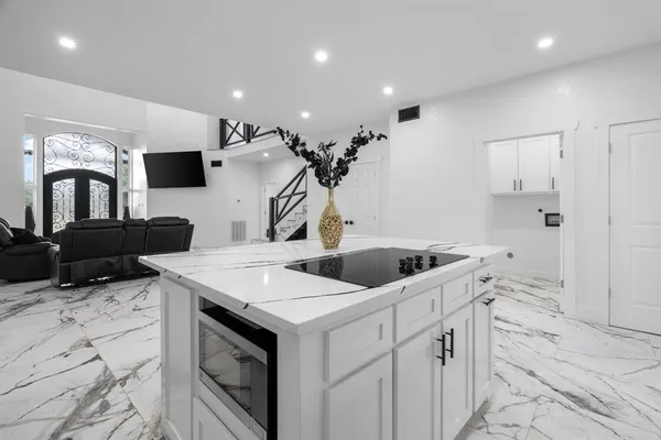 a kitchen with stainless steel appliances a sink a stove a refrigerator cabinets and living room view
