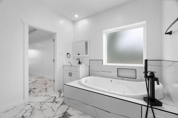 a spacious bathroom with a bathtub and shower