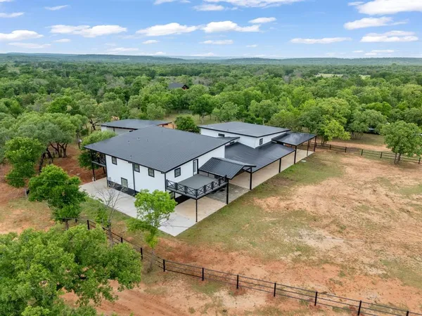 an aerial view of a house with pool garden and mountain view in back