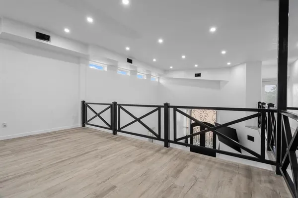 a view of an empty room with wooden floor