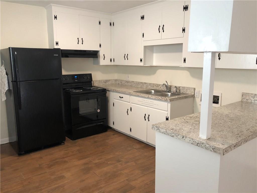 800 St James Church Road Newton, NC 28658 - Photo 17 of 27 a kitchen with granite countertop a refrigerator a stove and white cabinets