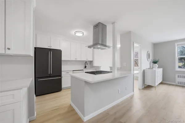 a kitchen with stainless steel appliances a refrigerator a sink a stove and white cabinets