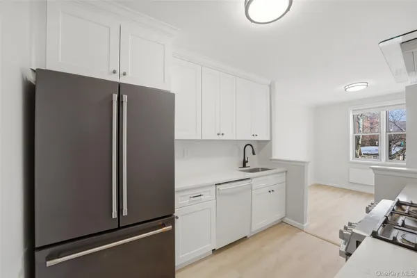 a kitchen with stainless steel appliances white cabinets and a refrigerator