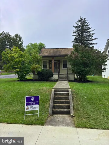 a front view of a house with a yard and a garden