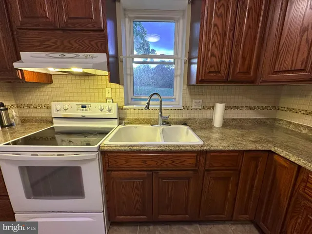 a kitchen with a sink stove and cabinets