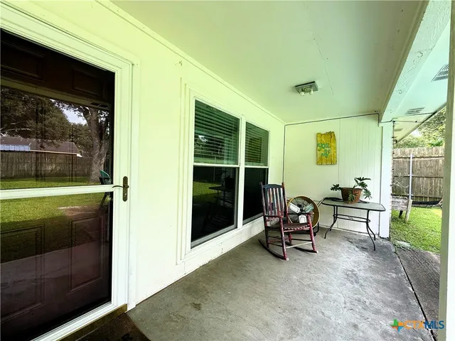 a view of a porch with chairs and a yard