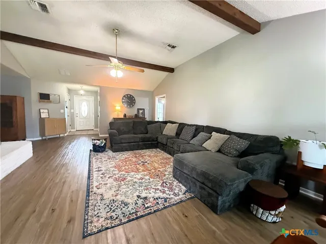 a living room with furniture and a wooden floor