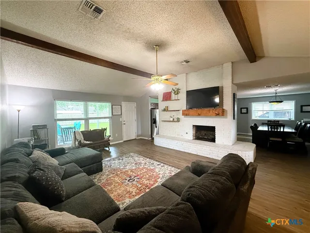 a living room with furniture a fireplace and a flat screen tv