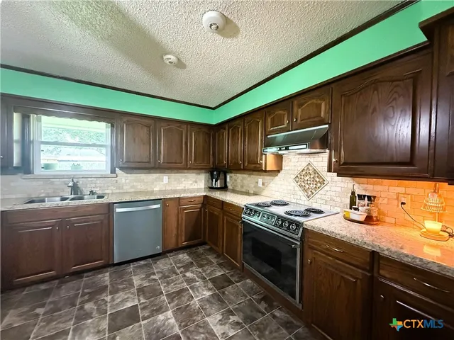 a kitchen with granite countertop stainless steel appliances and sink