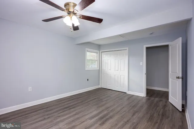 a view of a room with wooden floor and a ceiling fan