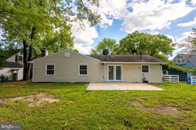 a house that has a big yard with plants and trees in front of it
