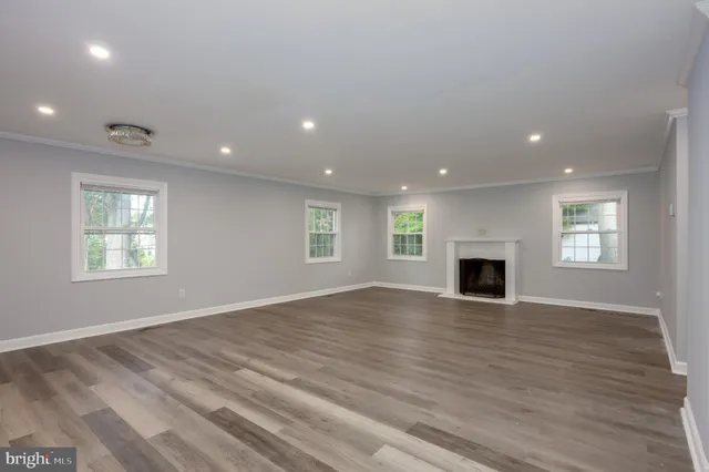 an empty room with wooden floor and fireplace