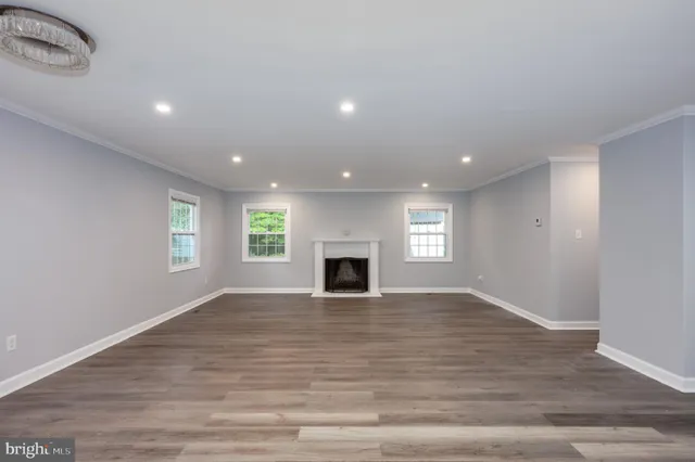 an empty room with wooden floor and fireplace