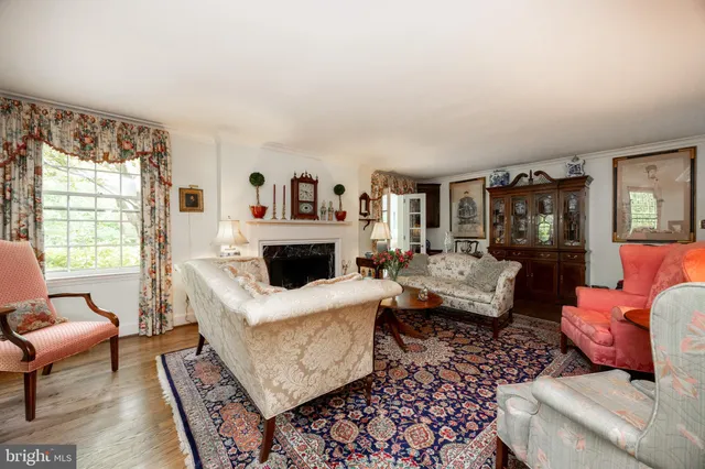 a living room with furniture a flat screen tv and a window
