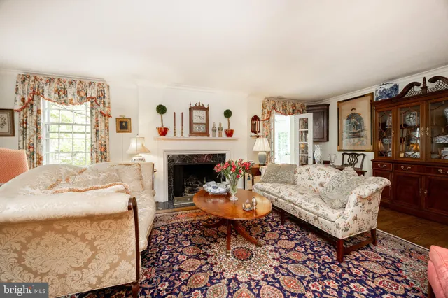 a living room with furniture a flat screen tv and a floor to ceiling window