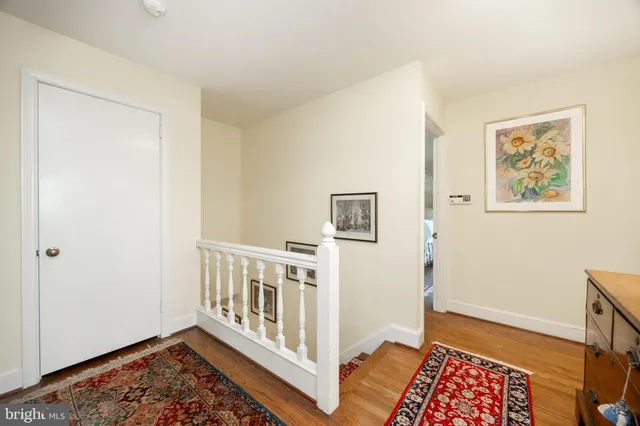a view of patio with table and chairs under an umbrella with wooden floor and fence