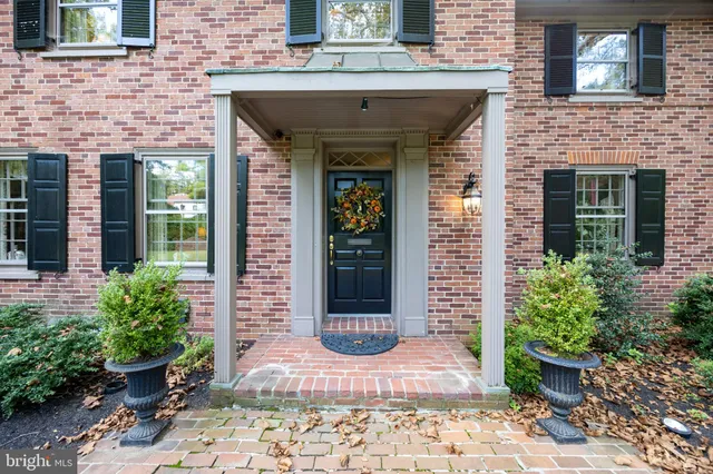 a stone house with potted plants in front of door