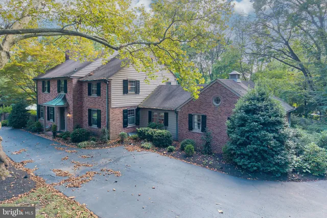 a view of a house with a yard and a large tree