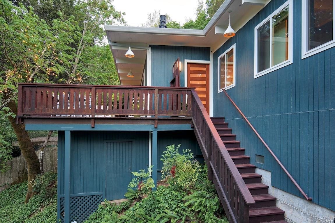 a view of front of house with deck and outdoor seating