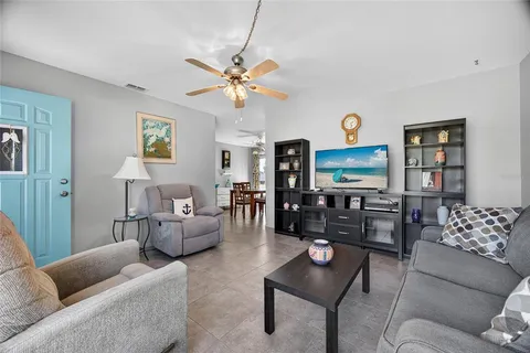 a living room with furniture a lamp and a flat screen tv