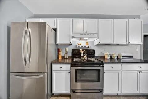 a kitchen with appliances a refrigerator and cabinets
