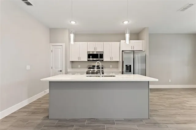 a kitchen with kitchen island sink stove and refrigerator