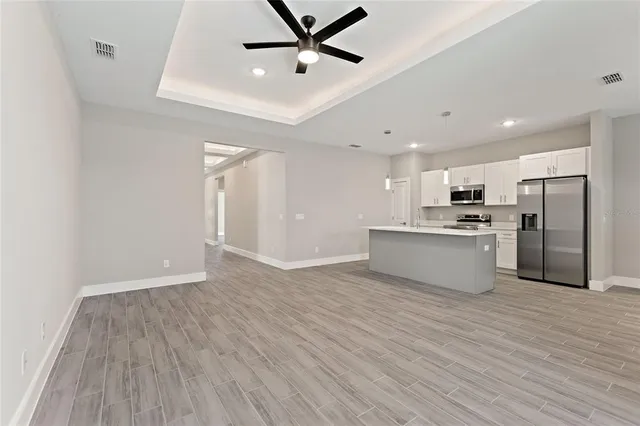 a view of kitchen with granite countertop cabinets and refrigerator