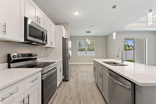 a kitchen with stainless steel appliances granite countertop a sink a stove top oven a counter space and cabinets