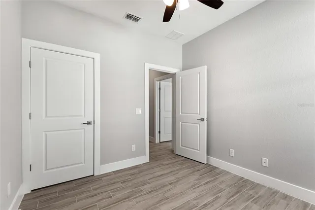 a view of an empty room with wooden floor