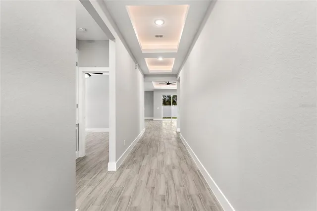 a view of a hallway with wooden floor and staircase