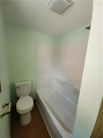 a white toilet sitting next to a sink