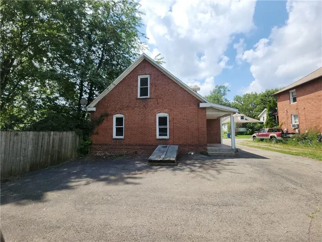 a view of a house with backyard and trees