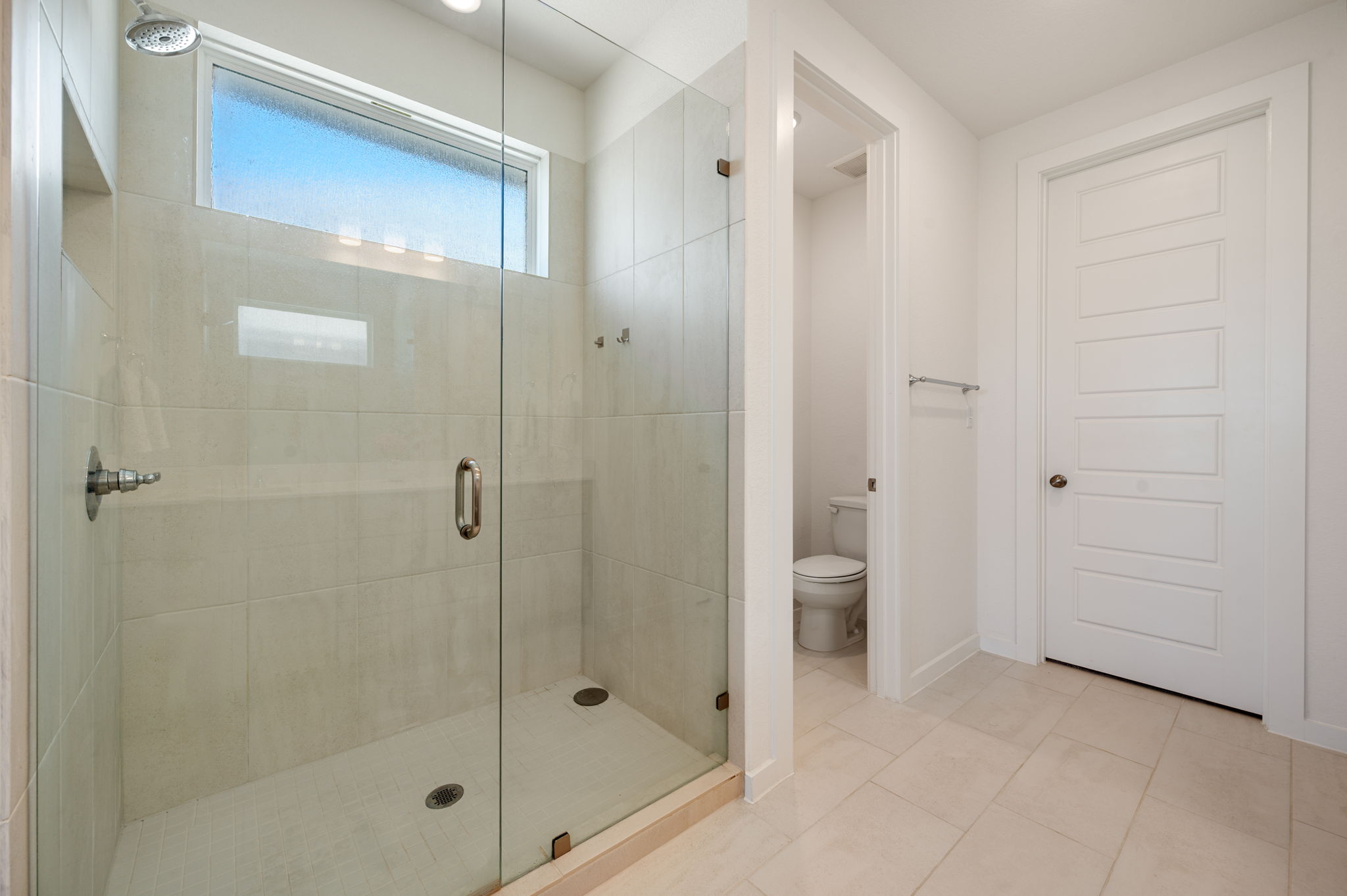 256 Comfort Maple Lane Dripping Springs, TX 78620 - Photo 22 of 39 The oversized frameless glass walk-in shower features a window for natural light in the bathroom.
