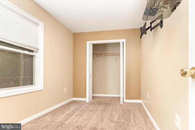 an empty room with windows and closet