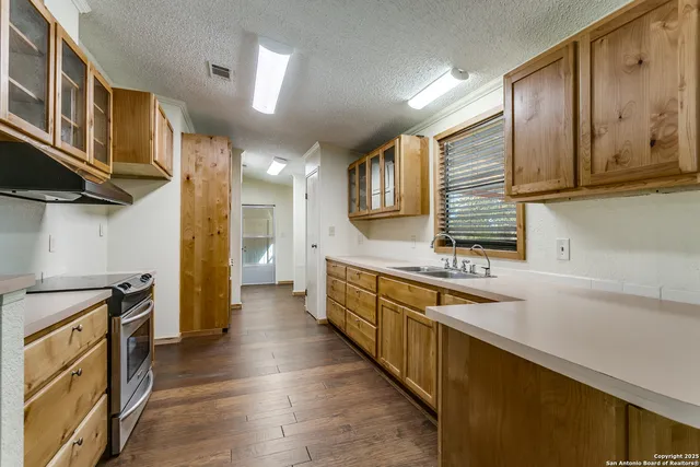 a kitchen with stainless steel appliances granite countertop a stove a sink and a refrigerator
