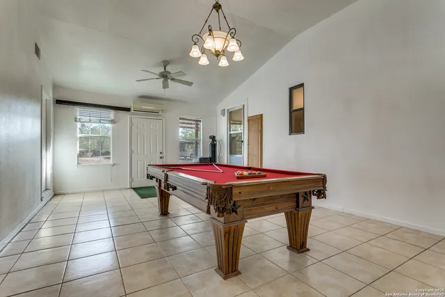 a room with pool table and windows