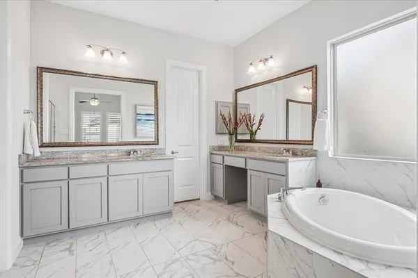 a bathroom with a bathtub sink and mirror